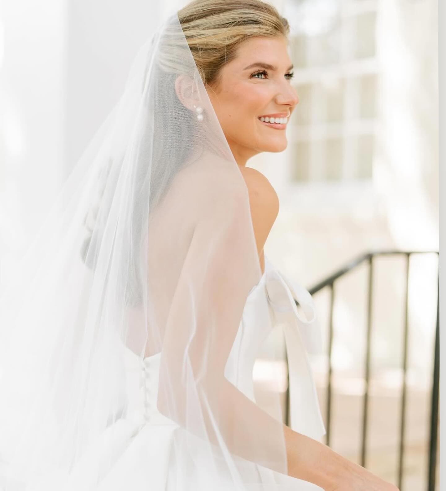 Bride with sleek updo, soft glam makeup and cathedral veil