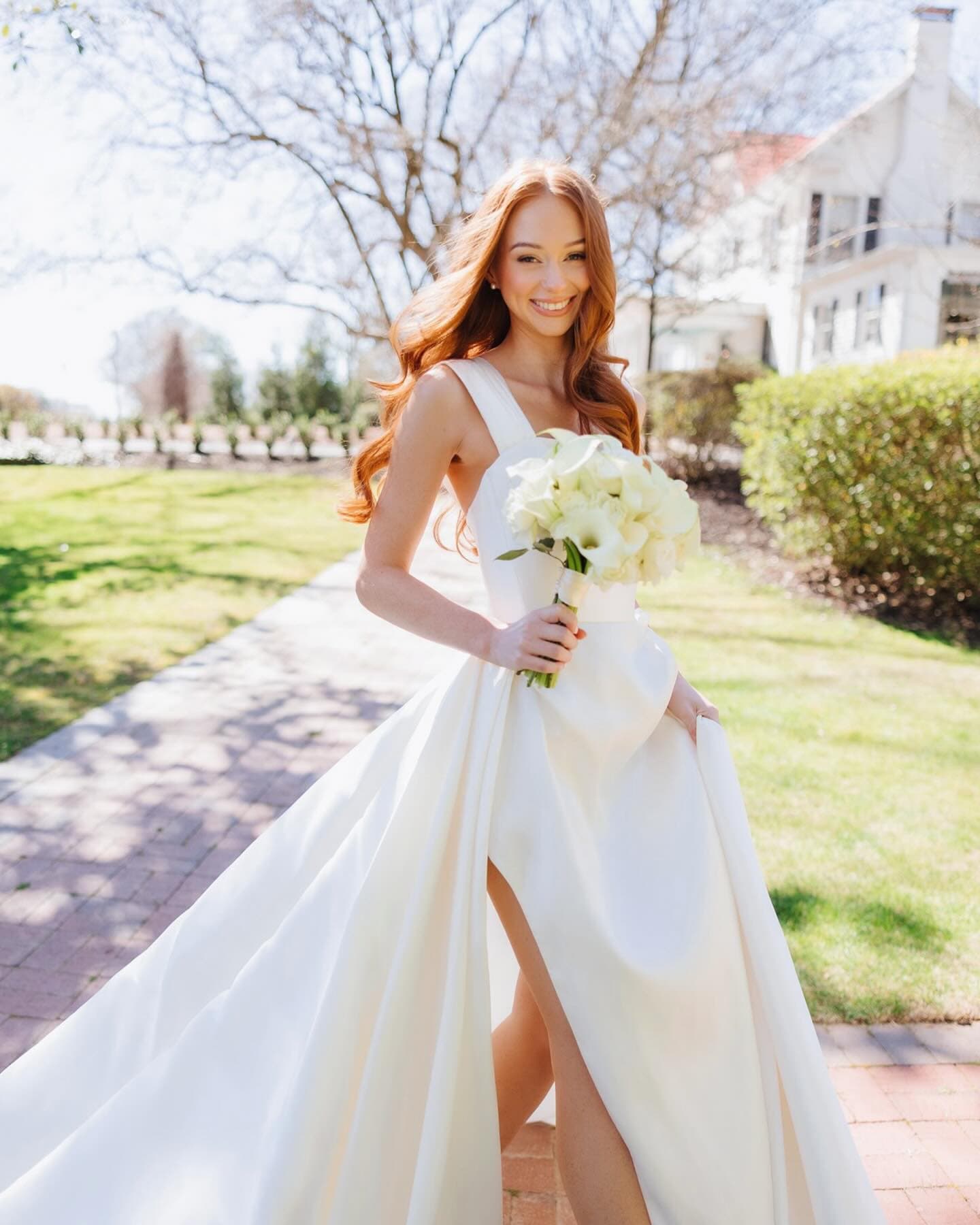 Red-haired bride with long curls and fresh natural makeup outdoors